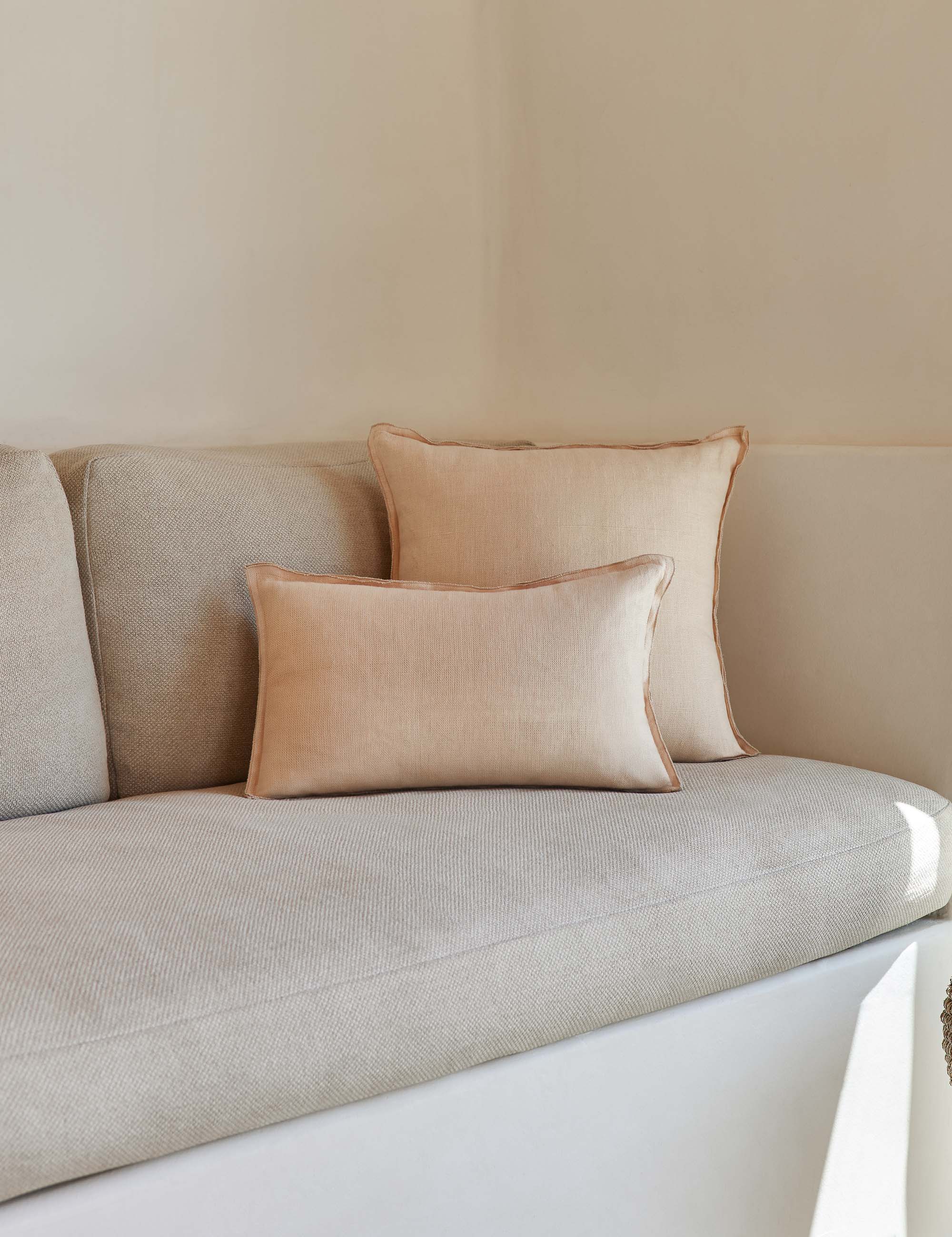The arlo Blush pink flax linen pillow in its lumber and square sizes sit together on a natural linen sofa