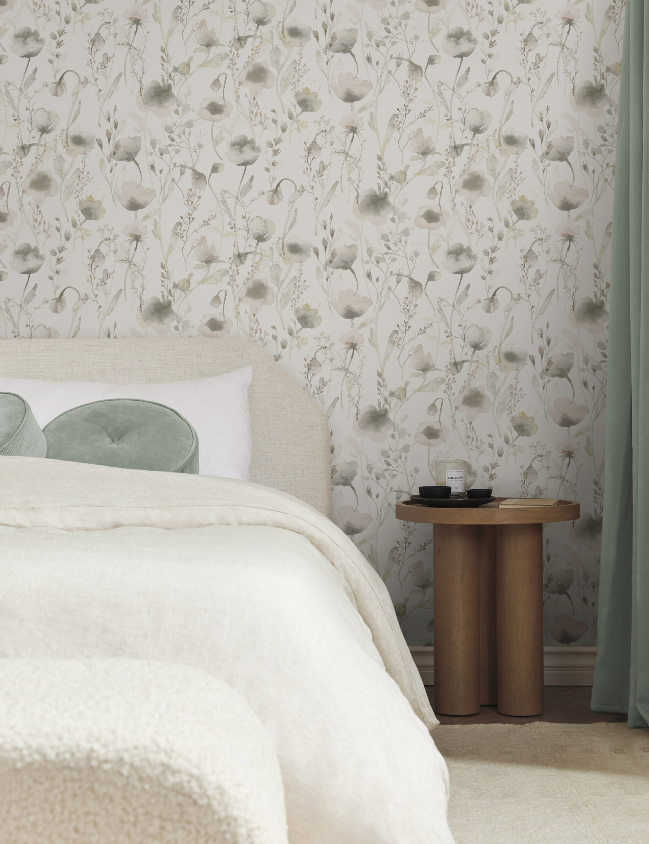 The Scalamandre Lo soft and pastoral gray toned floral wallpaper is in a bedroom with a natural linen framed bed, natural and cream toned bedding, and a wooden pedestal-base nightstand