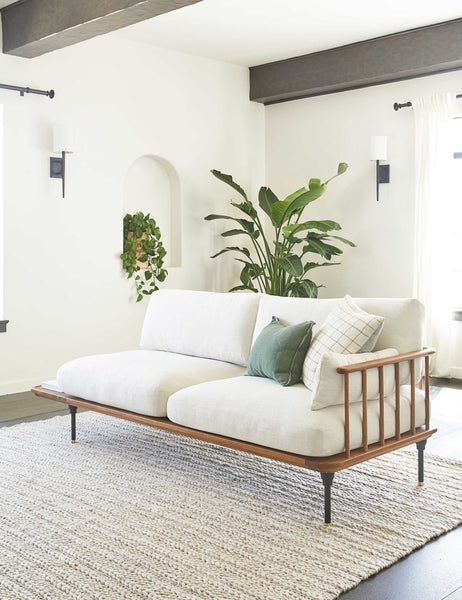 #size::3--x-5- #size::5--x-8- #size::8--x-10- #size::9--x-12- #color::soft-sand #size::10--x-14- | The Estie white rug with thick braids sits in a bright living room with a cushioned wooden sofa, black beamed ceilings, and plants throughout the room. | The Estie rug lays under a wooden-framed sofa with ivory cushions in a living room with wooden beamed ceilings