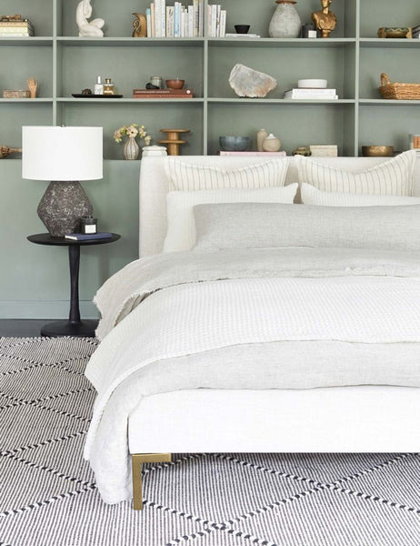 #showall::39490221342819 | The Deva Talc Linen platform bed lays in a bedroom with a green inset shelf atop a black and white rug