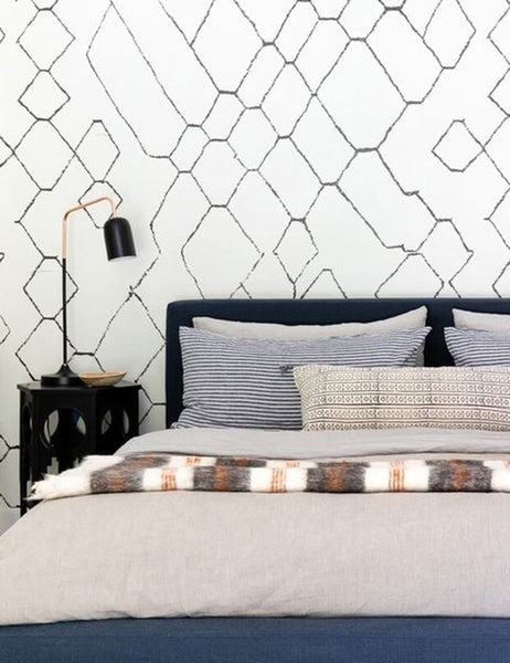 #color::indigo-stripe #size::euro-sham #size::king #size::standard  | The Set of two european flax linen indigo blue striped pillowcases by cultiver lay on a blue velvet framed bed in a bedroom with white and black patterned walls and a black hexagonal nightstand